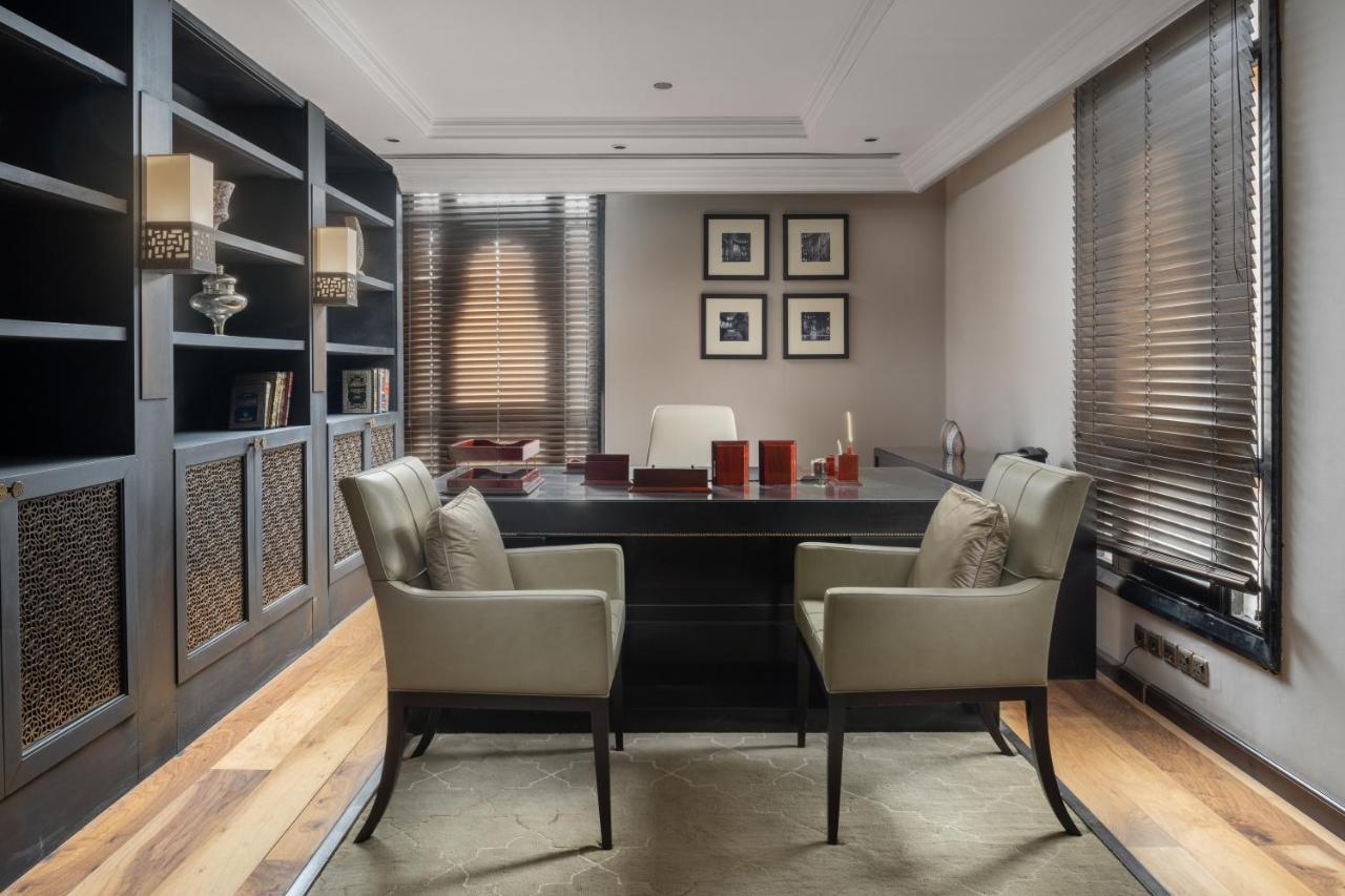 Sofitel Shahd Al Madinah Hotel Medina Exterior photo The photo depicts a modern office space. It features a large, dark wooden desk at the center, with two matching chairs positioned in front of it. Behind the desk is a minimalist white chair. The walls are adorned with framed pictures and there are bu