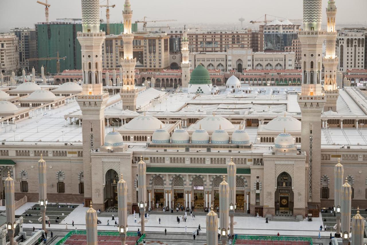 Sofitel Shahd Al Madinah Hotel Medina Exterior photo The photo shows an aerial view of a mosque complex, with prominent architectural features such as tall minarets and a large dome. The structure is notable for its intricate design and is likely surrounded by an open courtyard where people are gathere